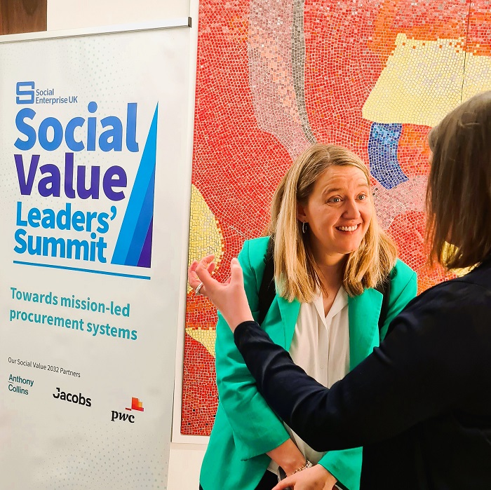 Georgia Gould in front of a Social Value Leaders' Summt banner
